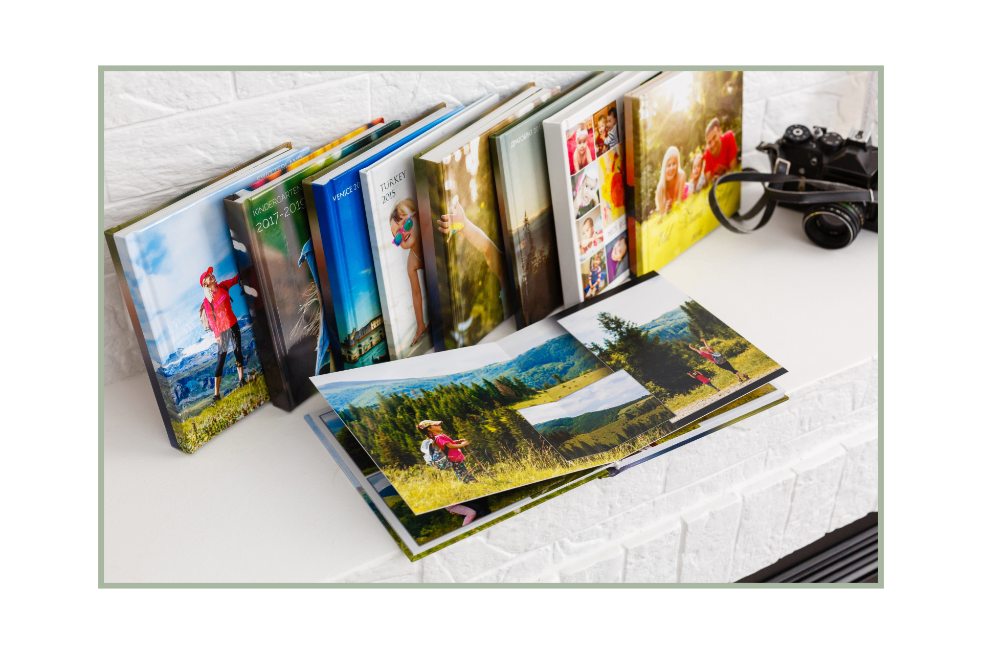 A collection of custom family photo books and an open album showing travel and family memories on a white surface